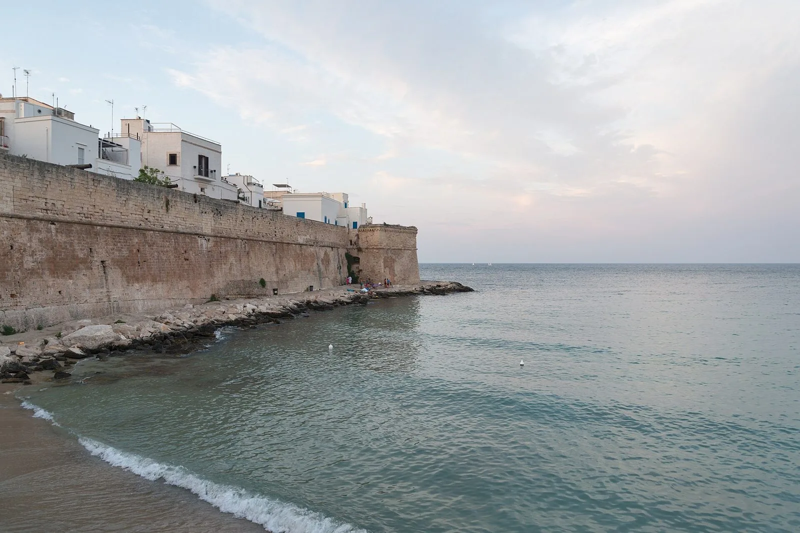 Le mura del centro storico di Monopoli affacciate sul mare a Cala Porta Vecchia, con le case bianche sopra i bastioni