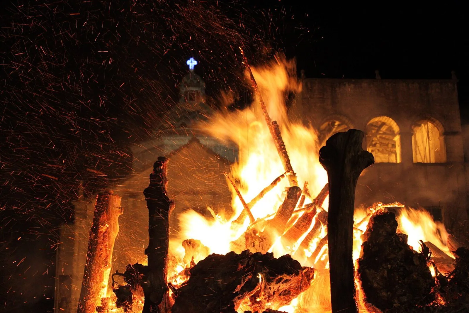 Grande falò delle Fanove acceso di notte davanti a una chiesa di Castellana Grotte