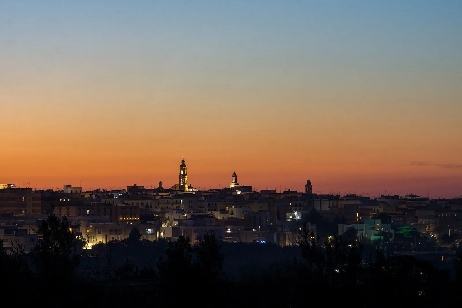 Profilo di Noci con i suoi campanili illuminati al tramonto